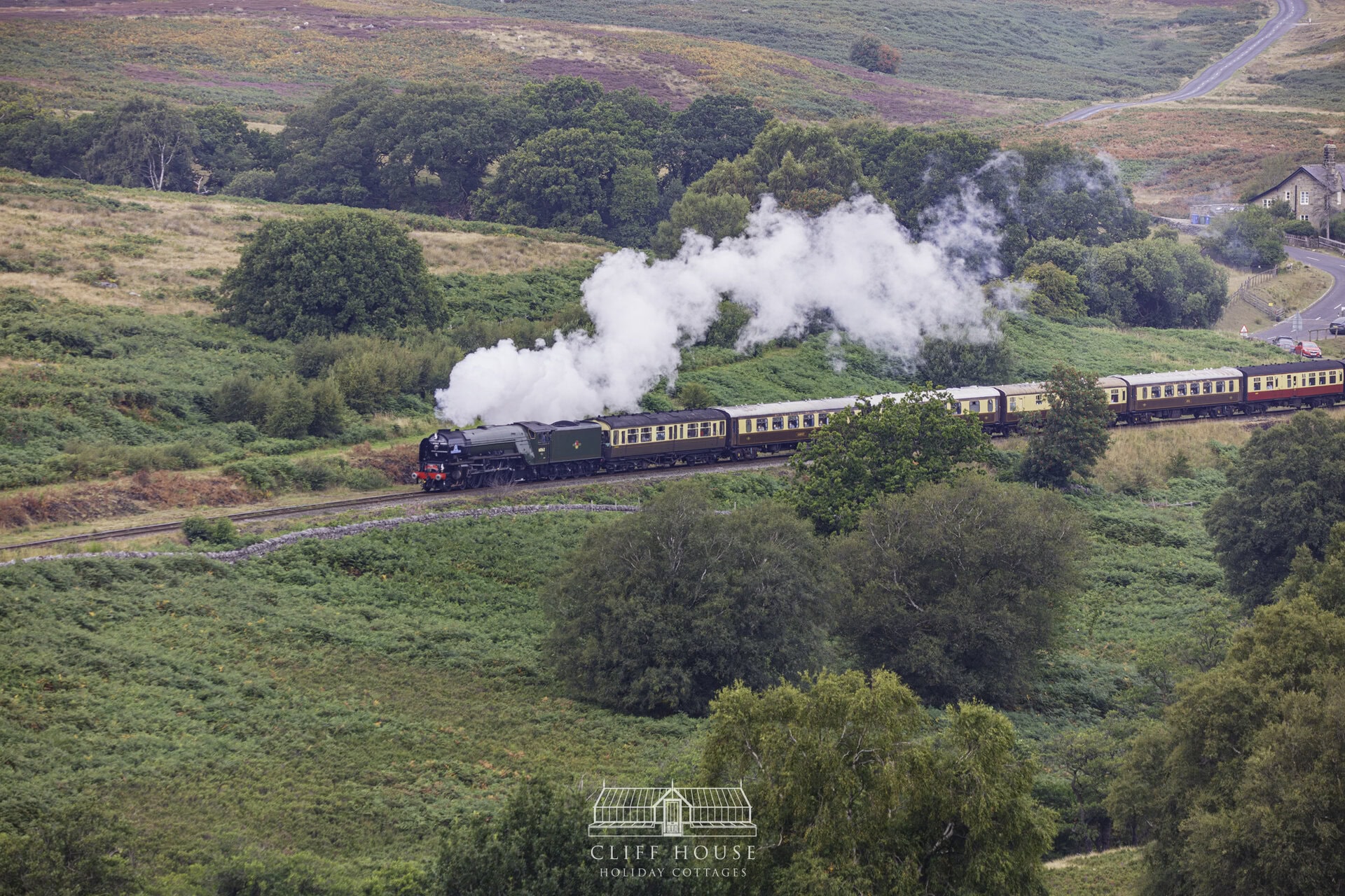 435a9320 cliff house holiday cottages steam train travelling through the north yorkshire moors railway surrounded by yorkshire countryside and historic station buildings steam train diaries